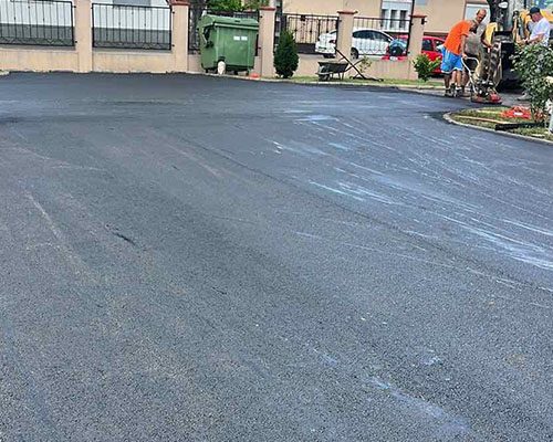 Parkoló aszfaltozása: nagy felület terítése és tömörítése társasház előtt