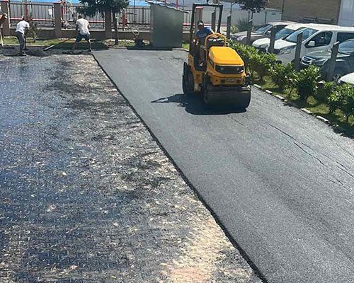 Udvar és parkoló kopóréteg tömörítése tandemhengerrel, kézi igazítással