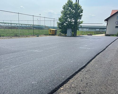 Nagy térburkolat frissen aszfaltozva, ipari telephelyen