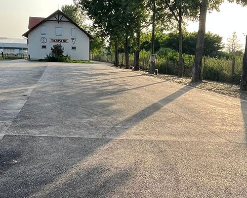 Telephelyi udvar kész aszfaltburkolata egy épület előtt